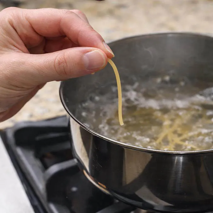 Checking Pasta for Al Dente Texture tasting pasta to check if it is al dente texture